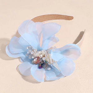 Detail of light blue chiffon flower headband with crystal beads and intricate petals