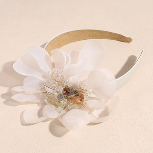 Detailed close-up of cream chiffon flower headband with sparkling crystal beads decor