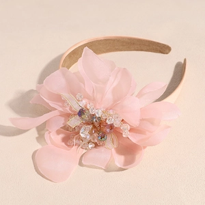 Detailed macro view of chiffon flower petals with crystal beads on a pink headband