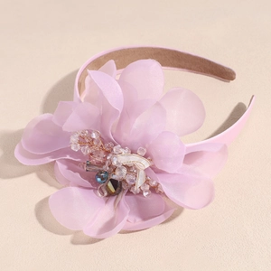 Close-up of pink chiffon flower headband with crystal beads and intricate gold wire detail