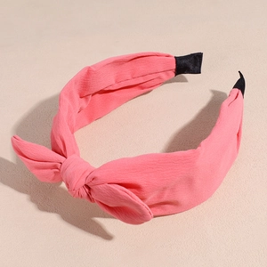 Detailed view of pink chiffon bow headband with textured fabric and comfortable black tips