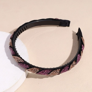 Dettaglio del cerchietto intrecciato con strass viola e denti interni antiscivolo