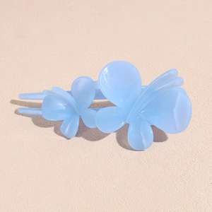 Détail de la pince à cheveux papillon double en résine bleue translucide au fini brillant