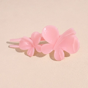 Vue détaillée de la pince à cheveux papillon rose translucide avec un design bec de canard