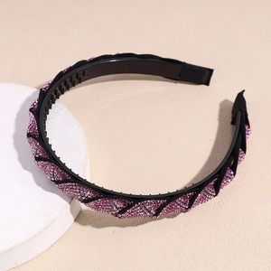 Dettaglio di un cerchietto intrecciato con strass rosa e denti interni antiscivolo