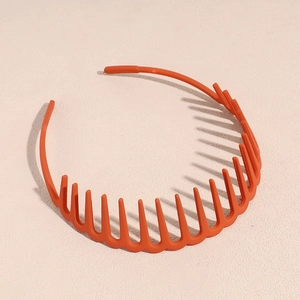 Vue détaillée du serre-tête orange montrant la structure ondulée antidérapante et dentelée