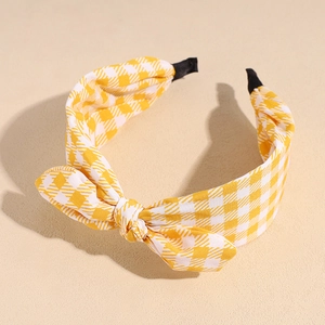 Detail of yellow plaid fabric headband featuring a cute bunny ear knot design and soft texture