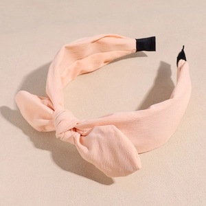Detail of light orange chiffon bow headband with black anti-slip tips for women