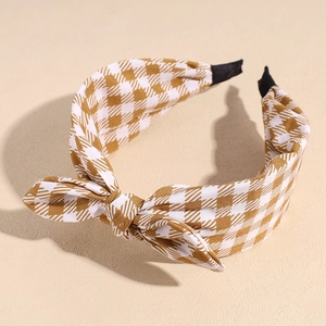 Detail of checkered bow headband showing yellow houndstooth fabric and soft texture