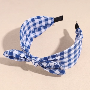 Detailed side view of blue and white checkered fabric headband with a stylish top knot