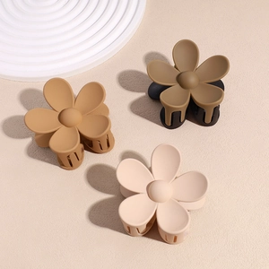Pinces à cheveux fleurs en crème, caramel et vert olive avec finition mate sur une surface