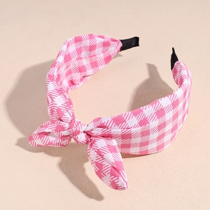 Detail of pink and white checkered fabric headband with bow and anti-slip ends
