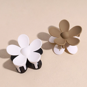 Pinces à cheveux fleurs mates en blanc et marron avec ombres douces sur fond beige