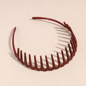 Détail macro du serre-tête ondulé rouge brique avec dents antidérapantes et fini mat