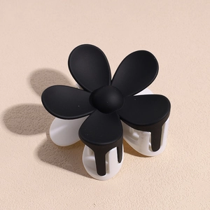 Détail d'une pince à cheveux fleur bicolore noire et blanche au fini mat