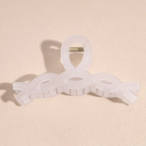 Macro detail of a large matte transparent white shark hair claw clip with metal spring
