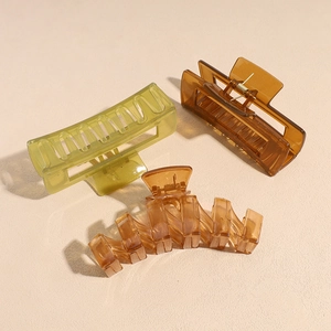Three large matte candy color shark hair clips in lemon green and amber tones