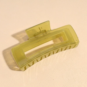 Detail of a large olive green hair claw clip showing the spring and rectangular cutout