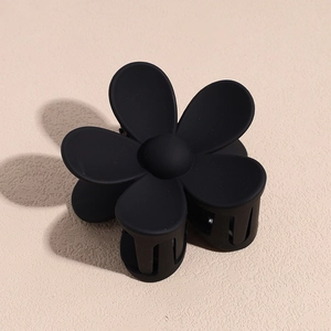 Pince à cheveux fleur noire mate avec un design minimaliste et une texture en résine