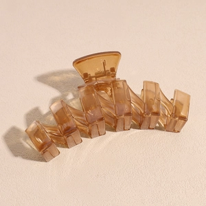 Macro shot of stylish translucent dark brown shark hair clip with geometric line design