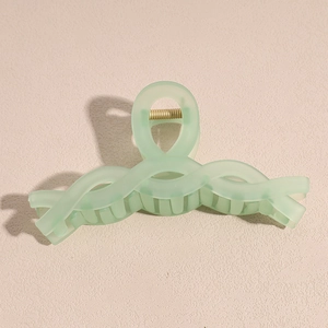 Detail view of large light green matte hair claw clip with strong golden metal spring
