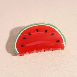 Vue détaillée d'une pince à cheveux en forme de pastèque aux couleurs rouge et verte