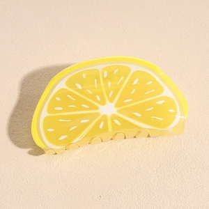 Gros plan détaillé d'une pince à cheveux en acrylique en forme de citron avec texture