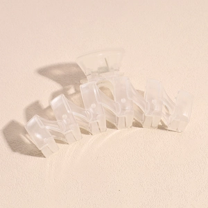 Macro view of matte white shark hair clip with interlocking geometric teeth detail