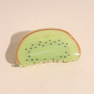 Gros plan détaillé d'une pince à cheveux en forme de kiwi en acrylique vert éclatant