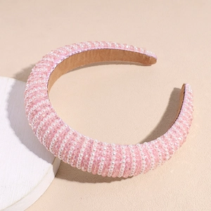 Gros plan sur un serre-tête rose rembourré avec perles et cristaux sur une assiette