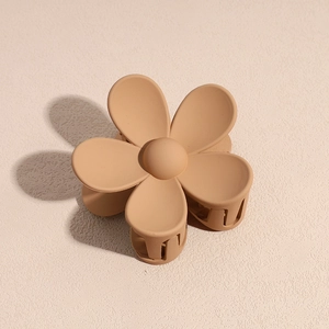 Détail de la pince à cheveux fleur mate en résine marron clair au fini élégant