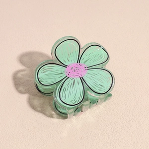 Dettaglio della molletta per capelli a fiore in acrilico verde menta con contorni neri