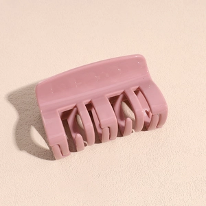 Gros plan d'une pince à cheveux citrouille rose pâle brillant avec détails des dents