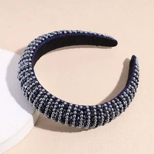 Gros plan du serre-tête perlé à la main avec cristaux gris sur tissu en velours bleu