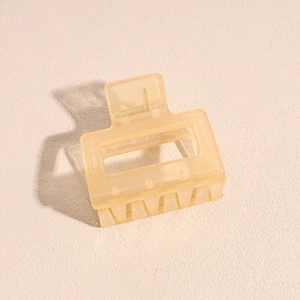 Macro detail of translucent yellow matte hair claw clip with hand made engraving