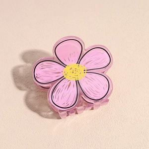 Dettaglio molletta per capelli a fiore in acrilico rosa con centro giallo e linee
