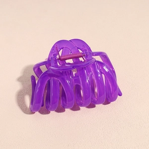 Gros plan d'une pince à cheveux citrouille violette avec ressort métallique robuste