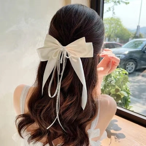Elegant cream satin bow hair clip with decorative pearls and ribbons for women