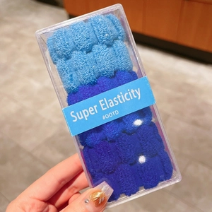 Détail d'élastiques à cheveux tricotés bleu dégradé dans un emballage transparent