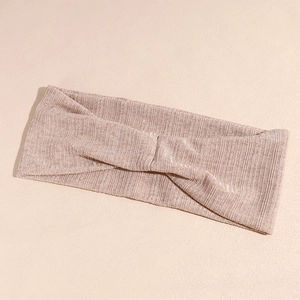 Détail d'un bandeau de yoga tricoté rose pastel avec texture côtelée et nœud croisé