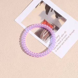 Dettaglio macro di elastico a spirale lilla iridescente con finitura perlata
