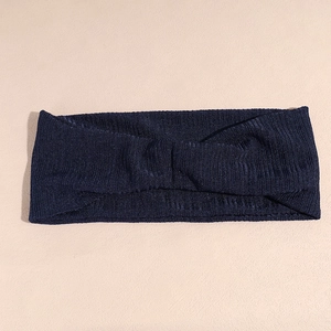 Détail de la texture en maille côtelée bleu marine et du nœud sur le bandeau sport