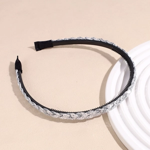 Détail des dents antidérapantes et de la texture tressée argentée du serre-tête chic