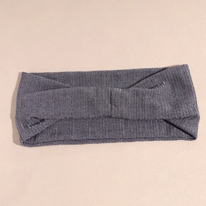 Détail macro du bandeau en maille grise avec texture côtelée verticale et design noué