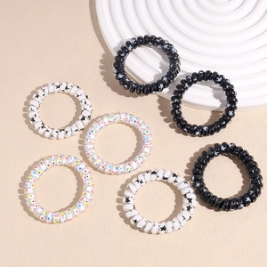 Set of 7 thick spiral telephone wire hair ties with black and star patterns on beige base