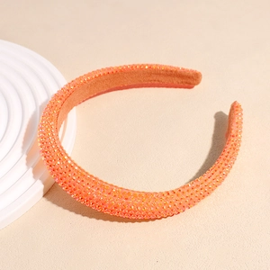Vue détaillée d'un serre-tête orange orné de strass brillants et d'une doublure en velours