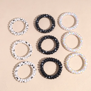 Set of 9 thick star pattern spiral telephone wire hair ties in black, white, and clear