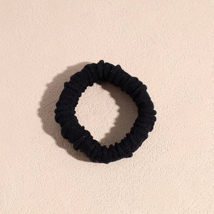 Dettaglio dell'elastico per capelli nero che mostra la trama del tessuto e le coste