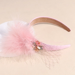 Close-up of pink feather headband with sparkling rhinestones and mesh veil detail