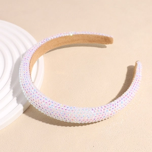 Gros plan d'un serre-tête rembourré avec strass irisés et doublure en velours marron